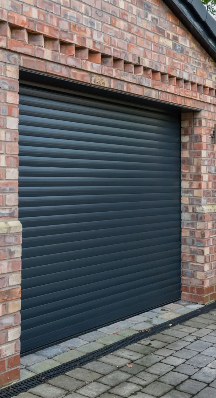 Anthracite roller garage door fitted by Excel in a brick garage